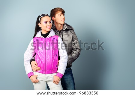 Couple of fashion models in winter, spring clothes posing at the studio.