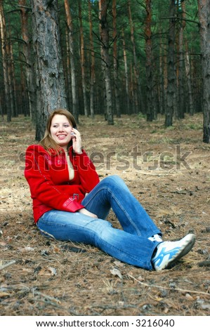 Girl talk for phone sitting under tree