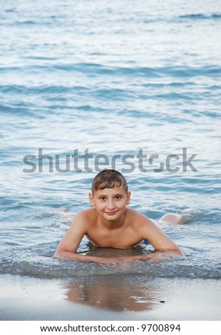 Swimming boy in sea waves
