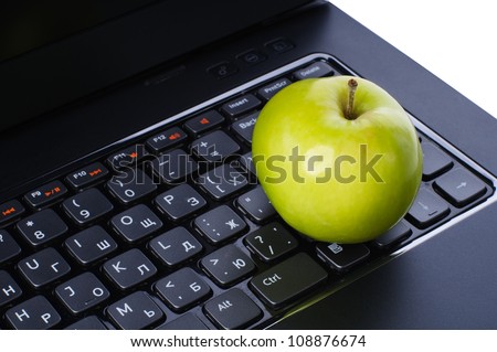 Green apple on laptop keyboard isolated on white background