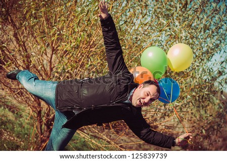 Young man with lot of balloons outdoor