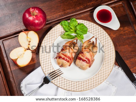 Two fried quails with bacon and apple sauce