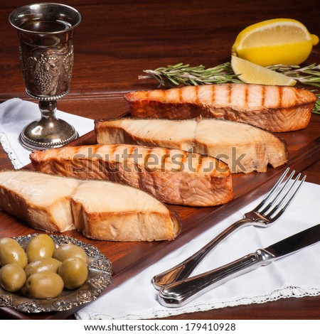 Four pieces of grilled salmon and sturgeon with olives