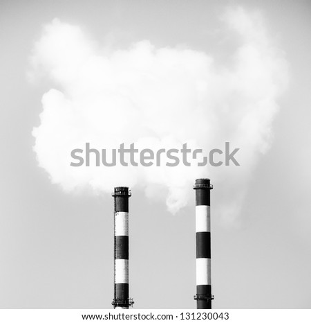 Two smoking chimneys pollution air, black and white monochrome