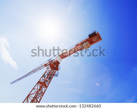 Construction site with crane and blue sky / lens flare