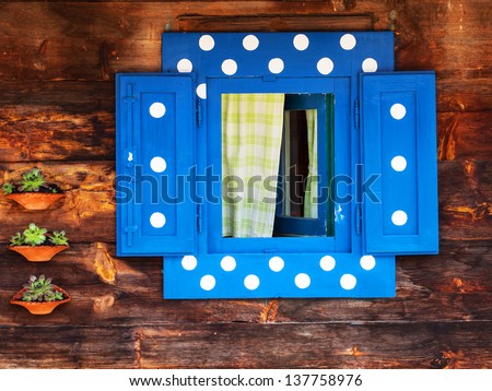 Blue window with white polka dots in an wooden peasant house, ethnic house and window