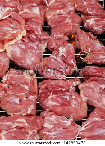 Pieces of fresh chicken meat on the grill