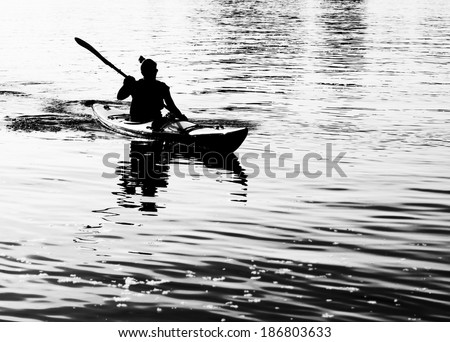 Silhouette of woman on ocean kayak
