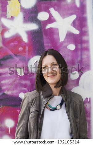 Attractive fashion woman with a graffiti background, vertical shot.