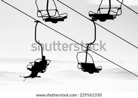 Ski lift chairs on bright winter day over the clouds, cableway funicular chair equipment, Garmisch Partenkirchen, Austria