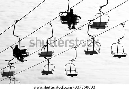 Ski lift chairs on bright winter day over the clouds, cableway funicular chair equipment