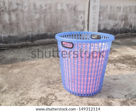 Empty white plastic laundry basket on old floor