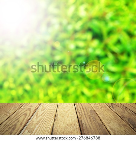 Empty wood table over blurred green plant with bokeh background, product display template,deck,
