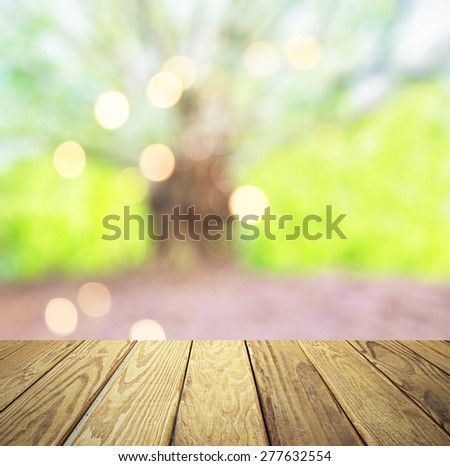 Empty wood table over blurred green tree with bokeh background, product display template,deck,