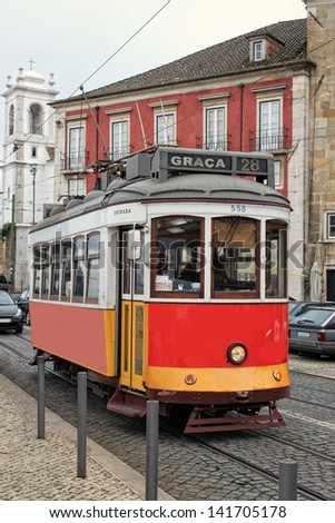 LISBON,PORTUGAL,APRIL19,2013: Historic number 28 red tram or streetcar on the cobblestone streets of Alfama, Lisbon, Portugal on April 19, 2013