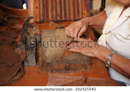 Woman makes and rolls cigars by hand in Trinidad, Cuba
