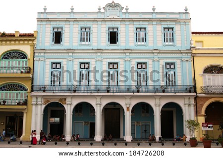 HAVANA, CUBA - FEBRUARY 21, 2014: Beautiful Colonial architecture and people hanging out outdoors in Havana, Cuba, a square in the old part of the city, on February 21, 2014