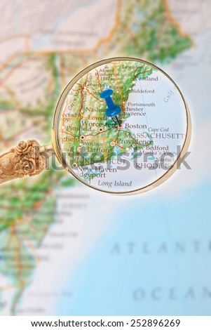 Blue tack on map of Eastern USA with magnifying glass looking in on Boston, Massachusetts