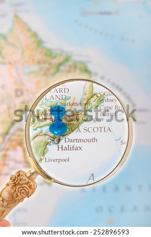 Blue tack on map of Canada with magnifying glass looking in on Halifax, Nova Scotia in the Maritme provinces in Eastern Canada