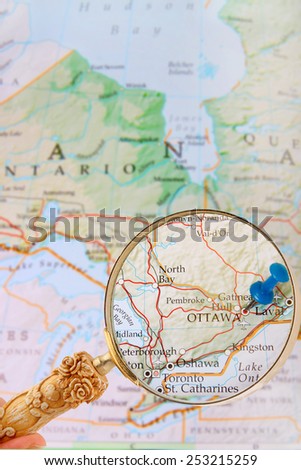 Blue tack on map of Ontario with magnifying glass looking in on Canada\'s capital city, Ottawa, Ontario