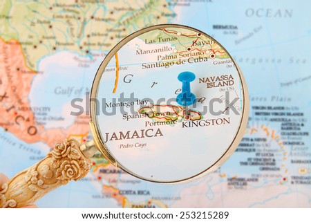 Blue tack on map of Caribbean with magnifying glass looking in on Kingston, Jamaica