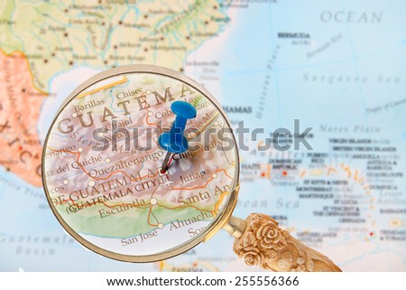 Blue tack on map of Central America with magnifying glass looking in on Guatemala City, Gatemala