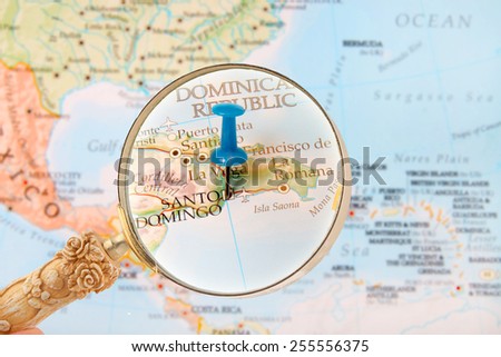 Blue tack on map of the Caribbean with magnifying glass looking in on Santo Domingo, Dominican Republic