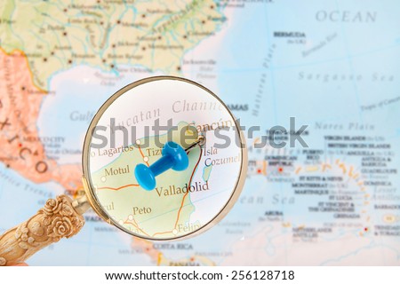 Blue tack on map of Caribbean with magnifying glass looking in on Cancun, Mexico
