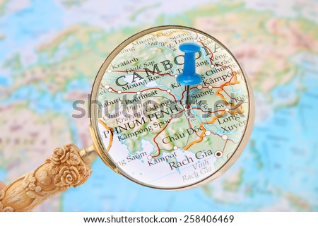 Blue tack on map Asia with magnifying glass looking in on Phnum Penh, Cambodia, Asia