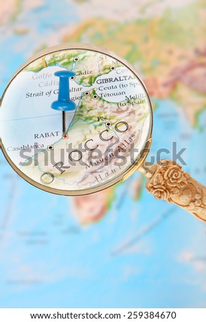 Blue tack on map of Africa with magnifying glass looking in on Rabat, Morocco,