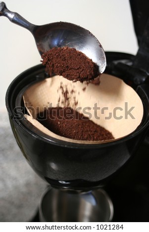 spooning coffee into coffee maker