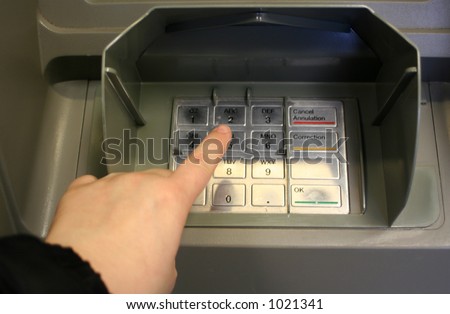 pressing personal code at ATM machine (focus on finger)