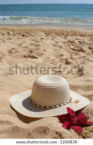 beach hat and flower in the sand