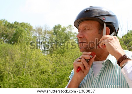 older gentleman puts on safety helmet for a bike ride