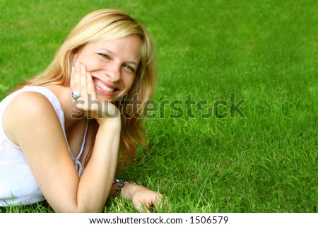 smiling woman relaxes on the grass