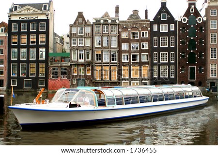 Amsterdam canal with with sightseeing tourism boat