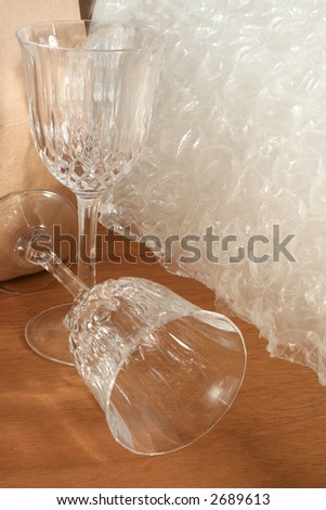 packing crystal glasses with protective bubble wrap and cardboard box