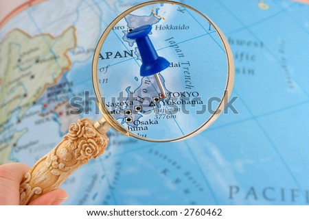 magnifying glass over Tokyo, Japan map with destination tack