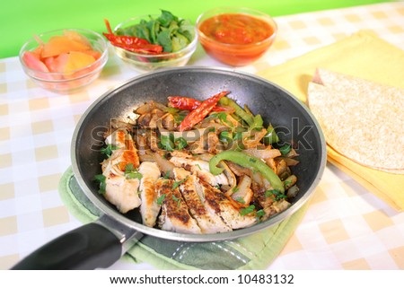 preparing delicious and colorful  mexican style  whole wheat chicken fajitas with vegetables, and salsa