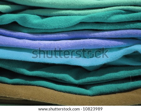 closeup of a pile of colorful tshirts freshly folded from the laundry
