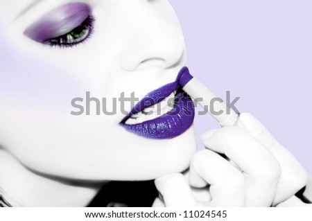 desaturated image with color enhanced on lips and eyes .... woman applying theatrical makeup