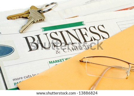 business section of the newspaper with yellow envelope and keys