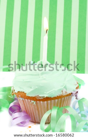 birthday cupcake with green frosting and decorative background