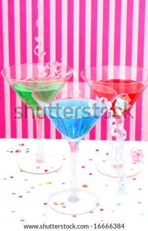 martini glasses with festive decorations like curled ribbons  with pink striped background