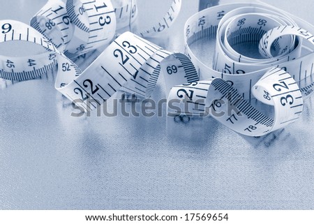 curled up measuring tape on silver background