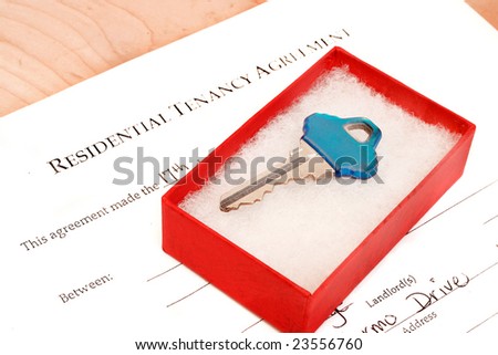 residential tenancy agreement document with blue  key inside gift box