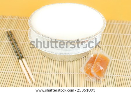 chinese food delivery or takeout aluminum covered containers on bamboo placemat with chopsticks and plum sauce,