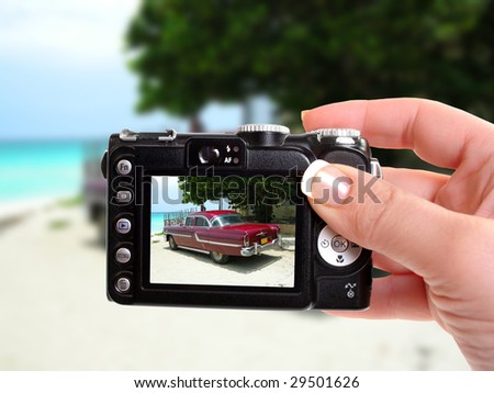 Taking a picture of a classic nostalgic car from the sixties on the shores of Varadero beach, Cuba