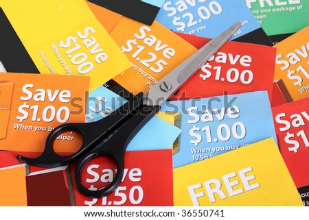 Cutting coupons in different colors, and price ranges from free to a few dollars (short depth of field)