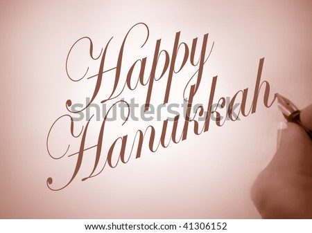 Person writing Happy Hanukkah in calligraphy with  sepia tone